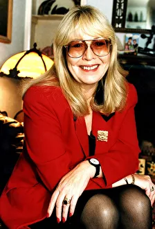Cynthia Lennon wearing red jacket with arms on knees and dark glasses December 1995 Cynthia Lennon wearing red jacket with arms on knees and dark glasses December 1995