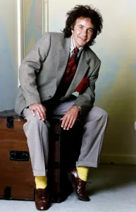 David Essex Singer sitting on a blanket box wearing a suit and yellow socks David Essex Singer sitting on a blanket box wearing a suit and yellow socks