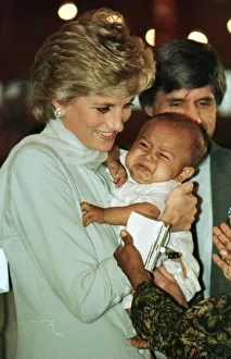 Diana, Princess of Wales holding a baby during prize giving ceremonies on a visit to Diana, Princess of Wales holding a baby during prize giving ceremonies on a visit to