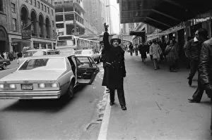 A doorman hailing a cab in New York, 13th February 1981 A doorman hailing a cab in New York, 13th February 1981