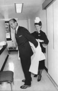 The Duke of Edinburgh. Prince Philip being helped with his protective clothing by Matron The Duke of Edinburgh. Prince Philip being helped with his protective clothing by Matron
