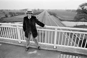Elton John pictured standing on a bridge over the motorway. 5th December 1982 Elton John pictured standing on a bridge over the motorway. 5th December 1982