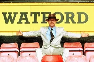 00236 Collection: Elton John on rejoining Watford football club as director sitting in front of sign white