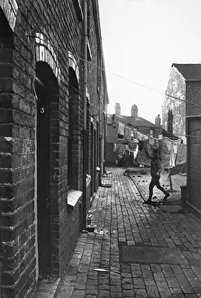Exterior view of a Birmingham terraced house showing a woman hanging out her laundry Exterior view of a Birmingham terraced house showing a woman hanging out her laundry