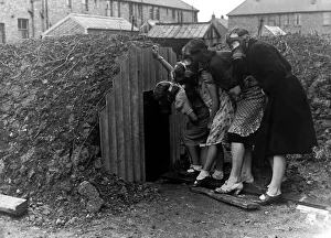 A family wearing gas masks go into an Anderson air raid shelter A family wearing gas masks go into an Anderson air raid shelter