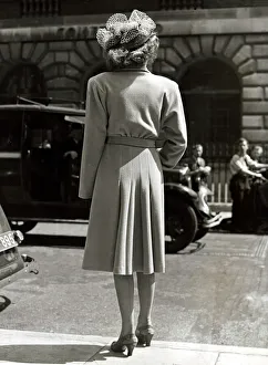 Fashion 1940s Model with her back to the camera wearing a pleated coat with doleen sleves Fashion 1940s Model with her back to the camera wearing a pleated coat with doleen sleves