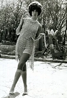 Fashion 1960s Model with an afro hair style standing outside dancing wearing a Fashion 1960s Model with an afro hair style standing outside dancing wearing a