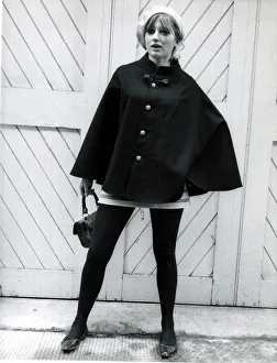 Fashion 1960s Model wearing a black cape, white beret Fashion 1960s Model wearing a black cape, white beret