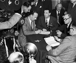 Footballer Tommy Lawton looks on as his new manager Jack Gibbons signs a contract after Footballer Tommy Lawton looks on as his new manager Jack Gibbons signs a contract after