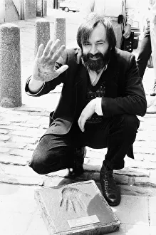 Bill Forsyth film producer making hand impression hand print in paving stone outside Bill Forsyth film producer making hand impression hand print in paving stone outside
