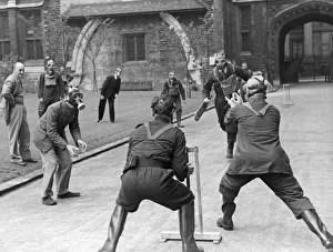 A game of cricket played in an English village by men wearing gas masks May 1941 A game of cricket played in an English village by men wearing gas masks May 1941
