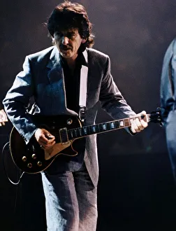 George Harrison on stage playing guitar October 1992 George Harrison on stage playing guitar October 1992