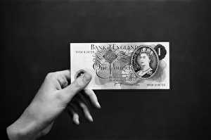A hand holding a pound note. 14th February 1974 A hand holding a pound note. 14th February 1974