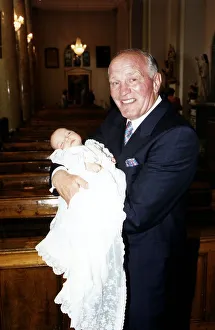 Henry Cooper, Boxing and Sports Personality holding his new grand child at Christening Henry Cooper, Boxing and Sports Personality holding his new grand child at Christening