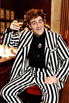 Iain McColl actor in black and white striped suit raising glass whisky toast STV Hogmanay Iain McColl actor in black and white striped suit raising glass whisky toast STV Hogmanay