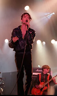 Jarvis Cocker of pop group Pulp singing into microphone on stage at T in the Park Jarvis Cocker of pop group Pulp singing into microphone on stage at T in the Park