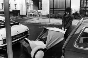 Jenny finds a convenient parking space for her Sinclair C5, between two cars Jenny finds a convenient parking space for her Sinclair C5, between two cars