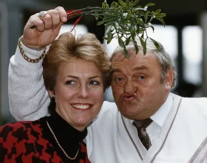 Jill Dando TV Presenter with Les Dawson who is holding mistletoe over their heads Jill Dando TV Presenter with Les Dawson who is holding mistletoe over their heads
