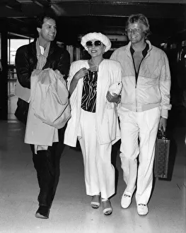 Joan Collins walking through Heathrow Airport with her boyfriend Peter Holm on her left Joan Collins walking through Heathrow Airport with her boyfriend Peter Holm on her left