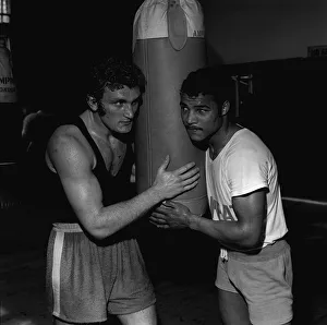 John Conteh and Joe Bugner in training by punch bag John Conteh and Joe Bugner in training by punch bag
