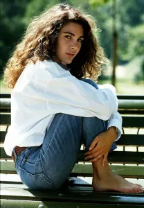 Laurence Ashley a French actress sitting sideways on a park bench with her feet up Laurence Ashley a French actress sitting sideways on a park bench with her feet up