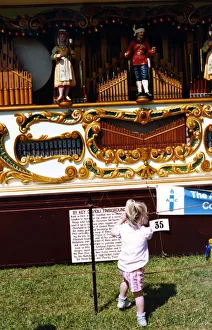 A little girl watching a fairground orgon at the Vintage Car A little girl watching a fairground orgon at the Vintage Car