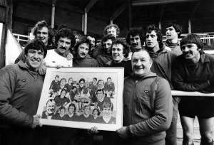 Liverpool football team players holding a photograph of the team Liverpool football team players holding a photograph of the team