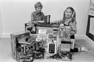Two lucky children surrounded by a selection of electronic games available in the shops Two lucky children surrounded by a selection of electronic games available in the shops