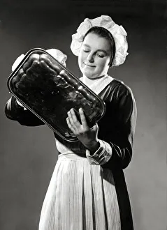 A maid polishing a silver tray, March 1938 A maid polishing a silver tray, March 1938