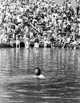 A man cools off by going for a swim in the pond in front of the stage at the Crystal A man cools off by going for a swim in the pond in front of the stage at the Crystal
