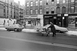 A man pushing a shopping trolley in the road in New York. 13th February 1981 A man pushing a shopping trolley in the road in New York. 13th February 1981