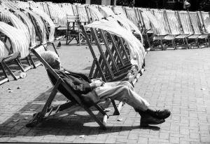 A man sleeps in a deckchair during windy weather at Brighton 31st August 1992 A man sleeps in a deckchair during windy weather at Brighton 31st August 1992