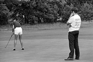 A man watches a woman playing golf during the Colgate European Women' A man watches a woman playing golf during the Colgate European Women'