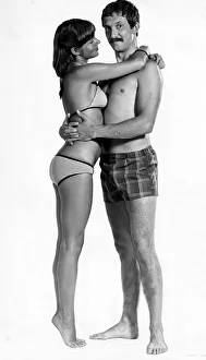 A man wearing checked shorts embracing a woman wearing a bikini August 1976 A man wearing checked shorts embracing a woman wearing a bikini August 1976