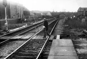 A man with a young child illegally crossing the railway line at West Jesmond Station A man with a young child illegally crossing the railway line at West Jesmond Station