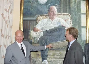 Manchester United director Bobby Charlton standing in front of a painting of him at Manchester United director Bobby Charlton standing in front of a painting of him at