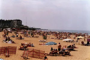 Margate Beach with tourists and daytrippers sunbathing. People sitting on deck chairs Margate Beach with tourists and daytrippers sunbathing. People sitting on deck chairs