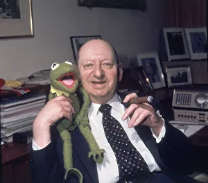 Media Mogul Lew Grade sitting at his desk smoking a cigar while holding Kermit the frog Media Mogul Lew Grade sitting at his desk smoking a cigar while holding Kermit the frog
