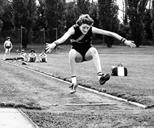 Melanie Moore throws her arms wide and bids for height and length in her long jump Melanie Moore throws her arms wide and bids for height and length in her long jump
