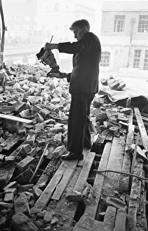 A member of staff holds a damaged instrument amongst the rubble of The Westminster A member of staff holds a damaged instrument amongst the rubble of The Westminster