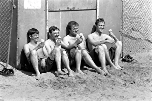Four men sitting enjoying an ice cream in the hot weather at Margate Beach Four men sitting enjoying an ice cream in the hot weather at Margate Beach