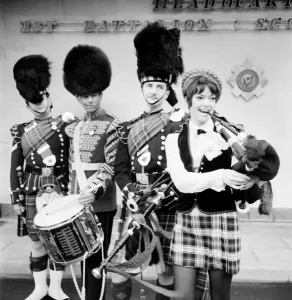 00031 Prints: Black and white print of a young woman attempting to play the bagpipes