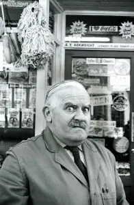 Prints of Ronnie Barker as the stuttering, miserly, lustful shopkeeper Arkwright from the BBC TV Series Open All Hours. Pictured in character outside his corner shop Mirror Prints: Ronnie Barker as Arkwright in Open All Hours Print, 1985