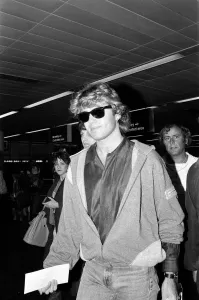 Prints of George Michael of the pop group Wham!, arriving at Gatwick airport on his return from China. 14th April 1985 0900to0999 Prints: George Michael at Gatwick Airport Print 14th April 1985