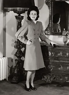 A model wearing a harella coat with new shaped sleeves and flared skirt standing beside a A model wearing a harella coat with new shaped sleeves and flared skirt standing beside a