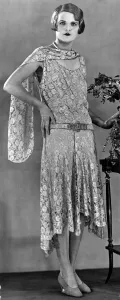A model wearing a long patterned dress showing the popular uneven hemline in 1929 A model wearing a long patterned dress showing the popular uneven hemline in 1929
