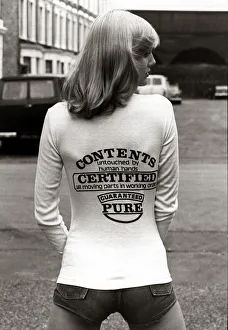 A model wearing a t-shirt with a joke message on the back August 1976 A model wearing a t-shirt with a joke message on the back August 1976