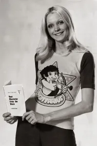 Model wearing a zodiac sign t-shirt witha cartoon of Sagittarius on it holding a book Model wearing a zodiac sign t-shirt witha cartoon of Sagittarius on it holding a book