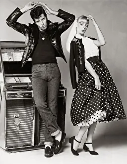 Models posing wearing fifties style fashion. man wearing jeans black t shirt Models posing wearing fifties style fashion. man wearing jeans black t shirt