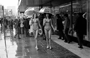 Images Dated 14th April 1975: Models Wendy and Jackie seen here modeling the latest in swimwear on a wet Oxford Street